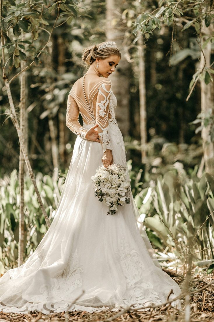 The back of a long-sleeved lace wedding gown with a row of pearl buttons